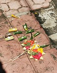 Op het trottoir moet je opletten, anders trap je op een offer. Hier bloemen en rijst in bananenblad.