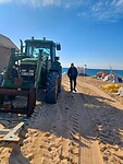De tractor staat klaar om de boten het strand op te trekken.