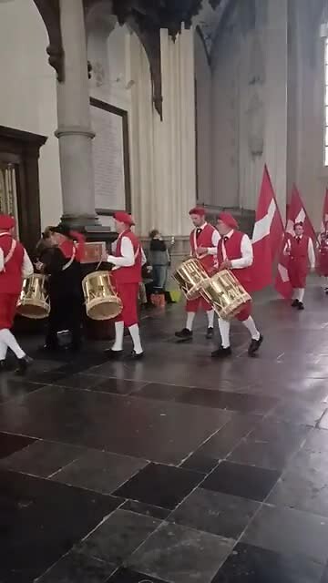 Vlaggendrager en tamboers verlaten de kerk