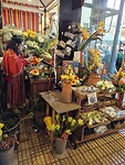 Veel bloemenstalletjes met dames in traditionele rok