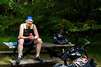 Henk op de picknickbank, terwijl Marja met het fototoestel rondbanjert