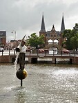 De man met de hoorn des overvloeds, met de Waterpoort op de achtergrond