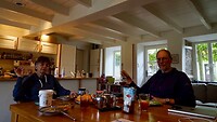 De jarige aan het ontbijt met het symbolische kado, het echte komt later