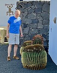 Henk bekijkt de cactussen in de tuin