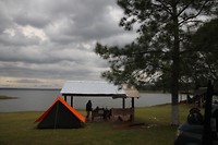 Een tent zet je naast of onder een afdak met zit en bbq gelegenheid, goede schaduw dus