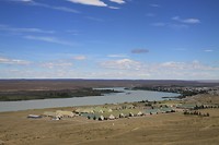 Plaats bij de rivier,  eenvormige maar grote huizen