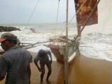 Trying to get the boat out of the water... the waves suck it in again...