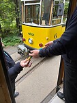 De overhandiging van een estafettestokje door de trammachinisten