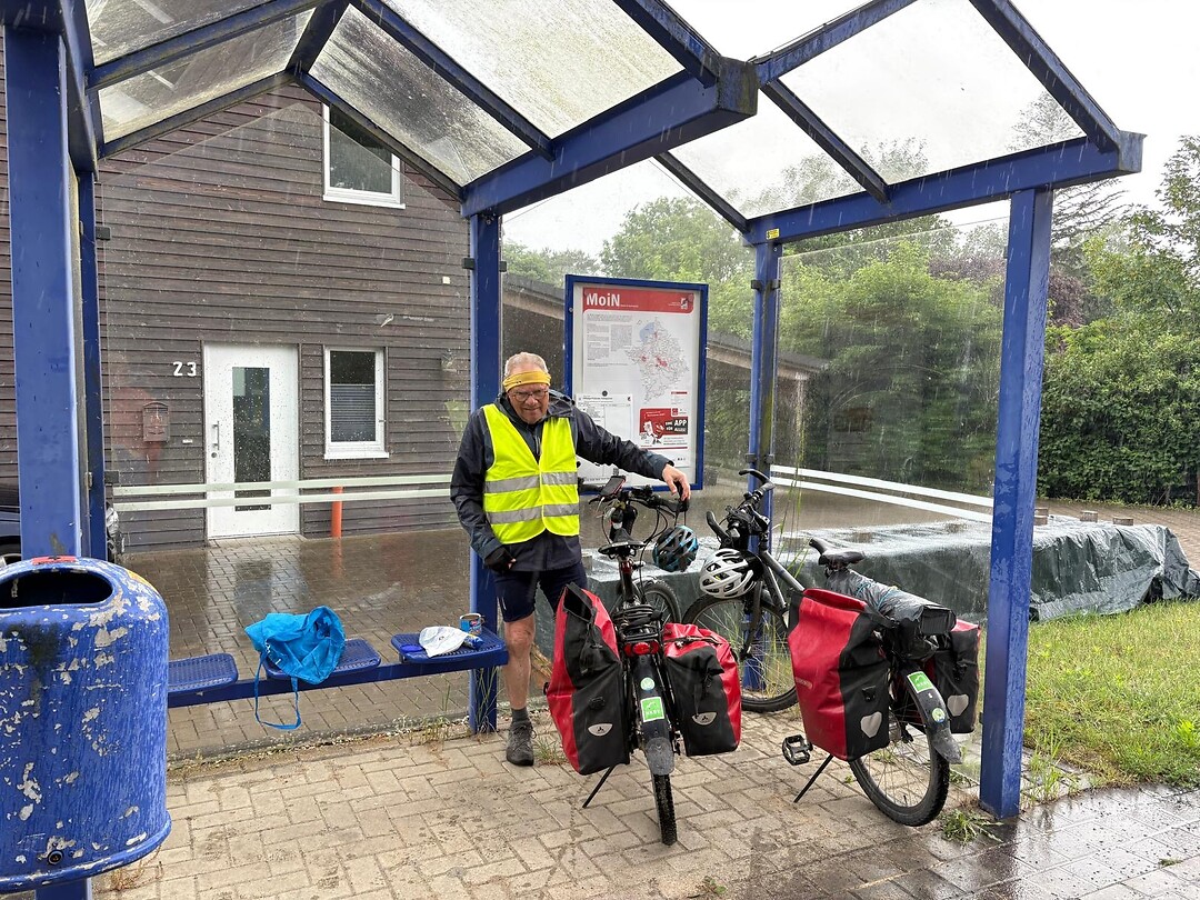 We staan droog in een bushokje.