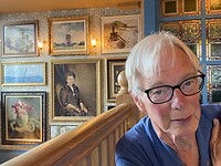 Klaas met een muur met mooie schilderijen