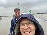 In de regen naar het vliegtuig lopen