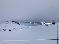 doorkijkje tussen de sneeuw en de laaghangende wolken