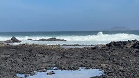 Ruige zee met Lanzarote op de achtergrond