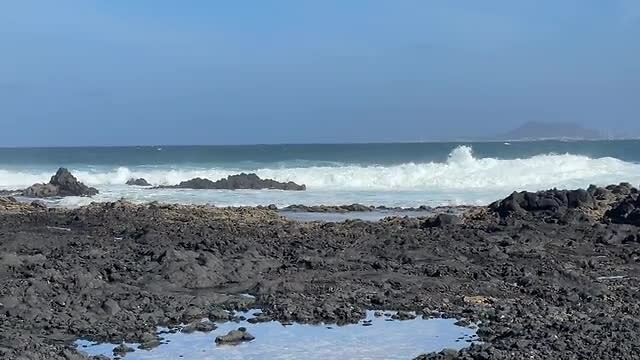 Ruige zee met Lanzarote op de achtergrond