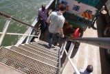 Impressie van de boot: onderaan de trap zit een mango-verkoopster