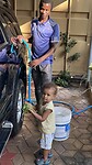 Neema helpt Anthony met auto wassen