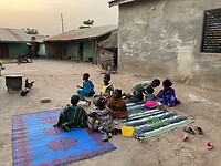 De kinderen zitten op de grond te eten.