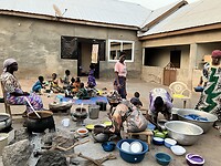De vrouwen van de compound verdelen het eten.