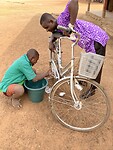 Adinan wast mijn fiets om te zien of hij mogelijk later auto’s kan wassen.