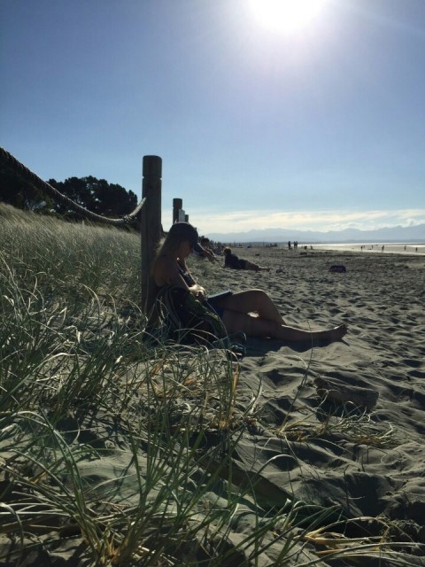 boekje lezen op strand van Nelson