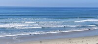 De oceaan, als je goed kijkt zie je de surfers.
