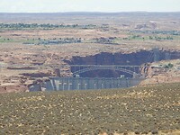 De bovenkant van de Glen Canyon Dam met de gelijknamige brug erachter