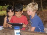 Na en Ra, de kinderen van de mensen waar we hebben overnacht, samen met Koen (en iPad)