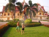 Koen en Fien zoeken verkoeling in een sproeier bij de Pha That Luang