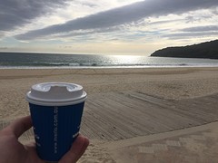 Kopje koffie in de morgen aan het verlaten strand