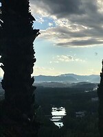Uitzicht over de Riu Onyar en de achterliggende bergen vanaf het bed op de kamer bovenop de Montjuic