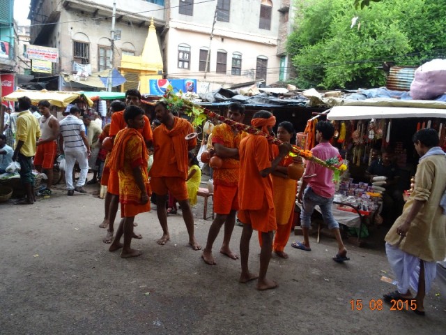 Aan de stok hangen bakjes om Ganges water mee te kunnen nemen naar een tempel