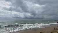Aan het strand pakken donkere wolken zich samen...