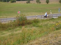 Deze man heeft drie tassen vol met geplukte vruchten van de bomen langs de weg