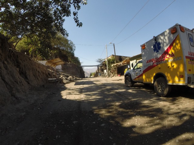 Onderweg klein dorpje met een dorpsambulance