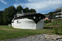 Bij appartementencomplex, terras op oude boot