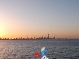Smurf passing Kuwait skyline at sunset