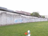 Smurf walking past one of the few remains of Berlin Wall
