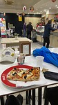 Warming up with a piece of pizza at the petrol station in Statigliano