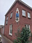 Aangekleed beeld op een woning in Groesbeek