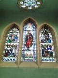 In de kerk een mooie glas in loodraam van een oude pelgrim in vol ornaat
