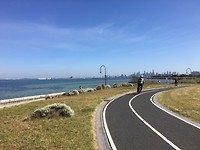 Prachtig fietspad langs het strand met de stad op de achtergrond