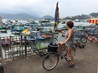 Vrouw op fiets bij haven