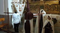 de kleding van de mensen die meelopen in de processie