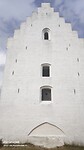 Alleen een deel van de toren steekt uit boven het duin