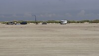 fotograaf staat aan de vloedlijn