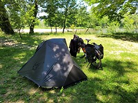 Tent, fiets, grasveld en rivier