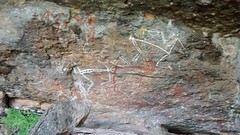 Rock carvings of people chasing a girl who stole food