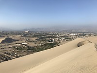 Boven op de zandduinen uitzicht op de naastgelegen stad Ica