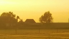 De zon is bijna onder. Boeren verplaatsen nog wat hooi