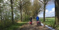 De mannen voorop met allebei een hondenkar achter de fiets